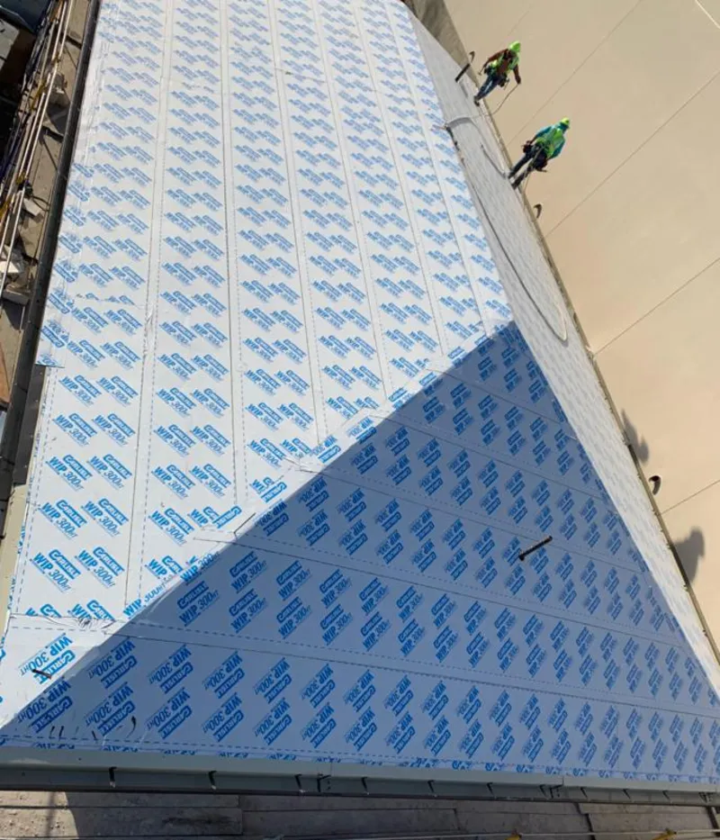 Professional roofers installing underlayment on a metal roof in Woodbury